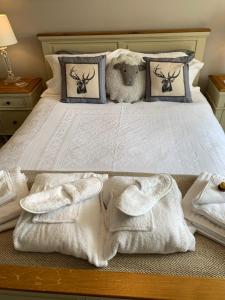 a bed with white towels and a teddy bear on it at Honeycott in Crickhowell