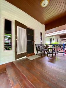 un porche con bancos y una puerta en una casa en Baan Soontree Resort, en Chiang Rai