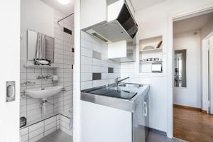 ein weißes Badezimmer mit einem Waschbecken und einem Spiegel in der Unterkunft Cooldis 6 !Gratis Parken, Free Parking! in Kreuzlingen