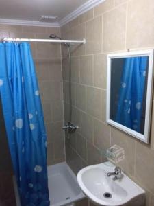 baño con cortina de ducha azul y lavamanos en Hostal AGUSTÍN II en Cartagena