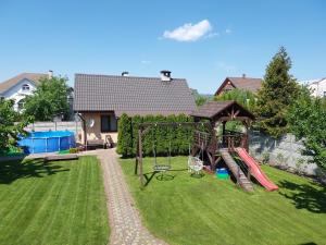 a yard with a playground with a swing at Happy Family House с баней in Brest