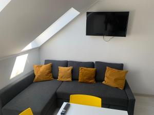 a living room with a gray couch with yellow pillows at AMBER Dębki in Dębki