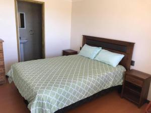 1 dormitorio con 1 cama con edredón verde en Hostal AGUSTÍN II en Cartagena