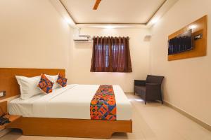 a bedroom with a bed and a chair in it at FabExpress Grand View in Bangalore