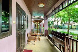 a porch of a house with a table and chairs at Baan Soontree Resort in Chiang Rai