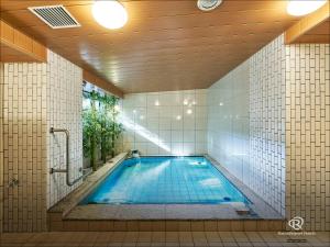 a swimming pool in a bathroom with a tile wall at Daiwa Roynet Hotel Nagoya Fushimi in Nagoya
