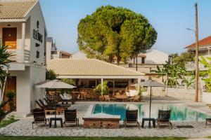 カボスにあるELEŌNAS bohotelのスイミングプール(椅子、テーブル、パラソル付)