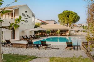 een hotel met een zwembad, stoelen en parasols bij ELEŌNAS bohotel in Kavos