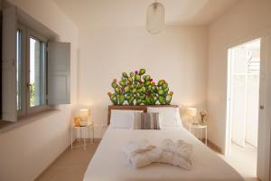 een slaapkamer met een groot bed met een plant aan de achterkant bij Floresia-Your Apulian Experience in Conversano