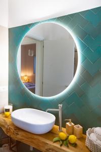 een badkamer met een wastafel en een spiegel bij Floresia-Your Apulian Experience in Conversano