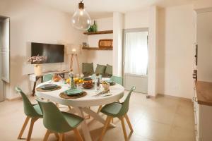een eetkamer met een witte tafel en groene stoelen bij Floresia-Your Apulian Experience in Conversano