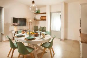 ein Esszimmer mit einem weißen Tisch und grünen Stühlen in der Unterkunft Floresia-Your Apulian Experience in Conversano