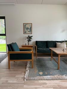 a living room with a couch and a table at Tyylikäs saunallinen huoneisto Sotkamon satamassa in Sotkamo