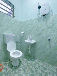 a bathroom with a toilet and a sink at Bauk View Homestay in Batu Lima