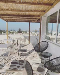 a patio with chairs and tables on a roof at Mare Naxia Hotel in Naxos Chora