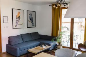 salon z niebieską kanapą i stołem w obiekcie Villa Monica Apartamenty w Szczyrku
