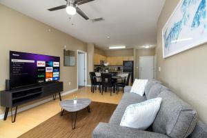 sala de estar con sofá y TV de pantalla plana en Private 2BR APT Downtown By RiverWalk en San Antonio