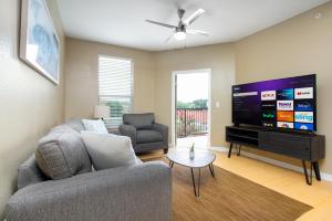 uma sala de estar com um sofá e uma televisão de ecrã plano em Private 2BR APT Downtown By RiverWalk em San Antonio