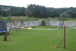 a group of swings in a grassy yard at Domki WIKA 2 in Ustka