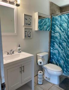 uma casa de banho com um WC branco e um lavatório. em North Shore Vacation Home - Best Views in V Land ! em Haleiwa