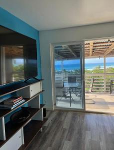 uma sala de estar com uma televisão de ecrã plano e um pátio em North Shore Vacation Home - Best Views in V Land ! em Haleiwa