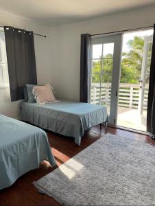 ハレイワにあるNorth Shore Vacation Home - Best Views in V Land !のベッドルーム1室(ベッド2台、大きな窓付)
