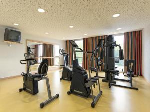 einen Fitnessraum mit mehreren Laufbändern und Crosstrainern in der Unterkunft B&B HOTEL Lully 3 Lakes in Estavayer-le-Lac