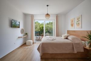 a bedroom with a bed and a large window at Apartments Endji in Čilipi