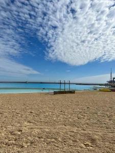 una playa de arena con un cielo nublado y el océano en Agradable Dp San Alfonso del Mar en Algarrobo