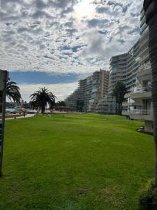 a green field with buildings and palm trees in a park at Agradable Dp San Alfonso del Mar in Algarrobo
