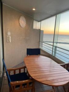 una mesa y sillas en una habitación con vistas al océano en Agradable Dp San Alfonso del Mar en Algarrobo
