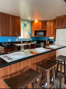 uma cozinha com armários de madeira e um balcão com bancos em North Shore Vacation Home - Best Views in V Land ! em Haleiwa