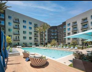 a large swimming pool with chairs and a building at Huge 2bd Apt Near Disneyland &Anaheim Conv Center 3Tofv in Anaheim