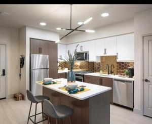 a kitchen with white cabinets and a large island with chairs at Huge 2bd Apt Near Disneyland &Anaheim Conv Center 3Tofv in Anaheim