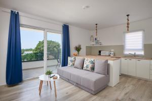 a living room with a couch and a kitchen at Apartments Endji in Čilipi