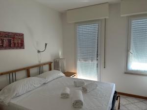 維洛納的住宿－Casa Bauli，白色卧室,配有带毛巾的床