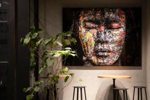 una pintura de un hombre en una pared con taburetes en the square hotel GINZA, en Tokio