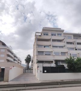 Un edificio blanco con palmeras delante. en Sea view Penthouse Denia, ELEGANCE, en Denia