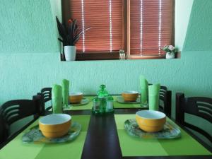mesa de comedor con sillas y mesa verde en LianaApartament, en Sandanski