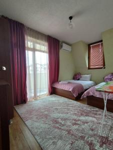1 dormitorio con 2 camas y ventana grande en LianaApartament en Sandanski