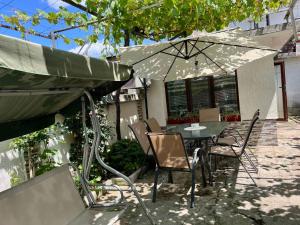 un tavolo e delle sedie sotto un ombrellone in un patio di Guest House Pri Germanetsa a Pavel Banya