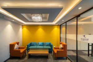 a waiting room with a blue couch and chairs at Sparrow Hotels managed by Siara in Alwar