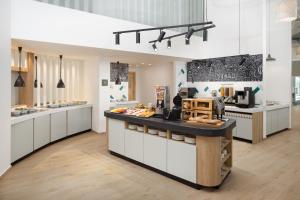 a kitchen with white cabinets and a black counter top at Hampton By Hilton Targu Mures in Târgu-Mureş
