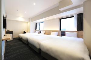 Una cama o camas en una habitación de Henn na Hotel Premier Nagoya Fushimiekimae