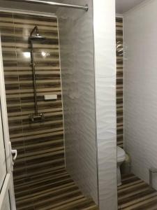een badkamer met een glazen douche en een toilet bij HalalHostel in Osh