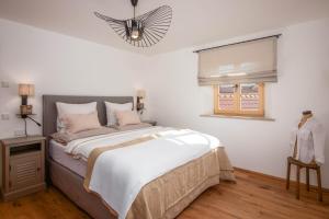 a bedroom with a large bed and a window at MY STAY- Erholung zwischen See und Bergen, neu erbaute Apartments im modernen Landhausstil mit Bergblick, familienfreundlich in Fischbachau