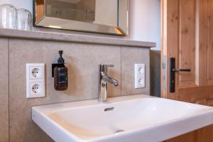 a white sink in a bathroom with a mirror at MY STAY- Erholung zwischen See und Bergen, neu erbaute Apartments im modernen Landhausstil mit Bergblick, familienfreundlich in Fischbachau +34 photos