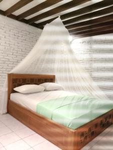 a bedroom with a bed with a net above it at Jungle House - surf & stay in Pulukan