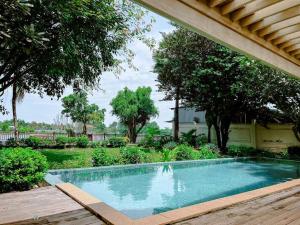 una piscina en un patio con árboles en Riverside French Villa, en Thuan An