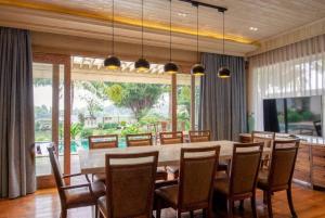 a dining room with a large table and chairs at Riverside French Villa in Thuan An